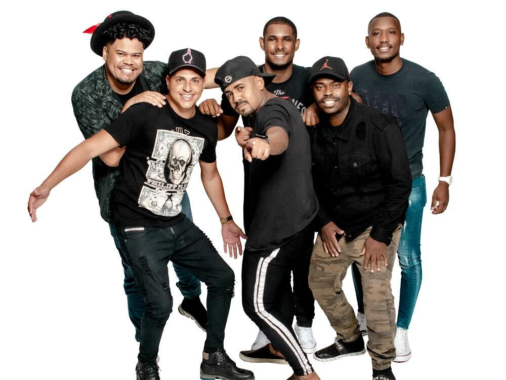 A imagem mostra os seis integrantes do Grupo Axtral. Eles sorriem para a câmera e todos usam blusas escuras. Todos eles são negros e jovens.