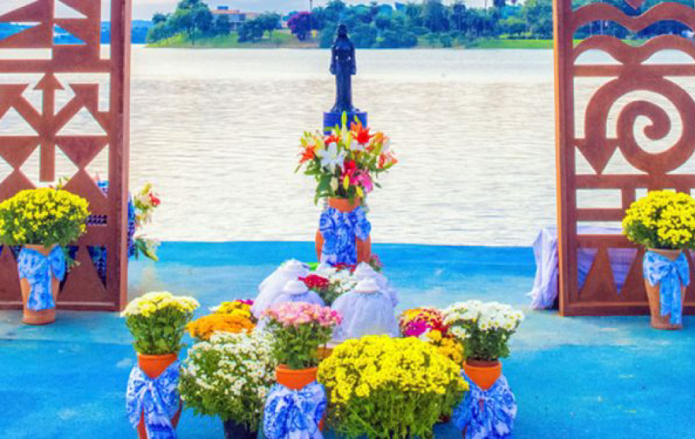 É possível notar uma foto de uma imagem de Iemanjá, cercada por flores
