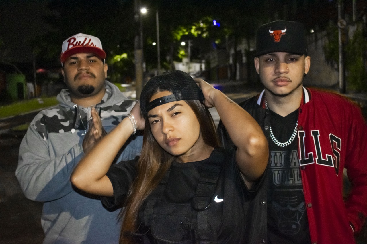 Fotografia do grupo de Rap Setor. Estão na foto em close Gaby, Mateus e Sandrão.