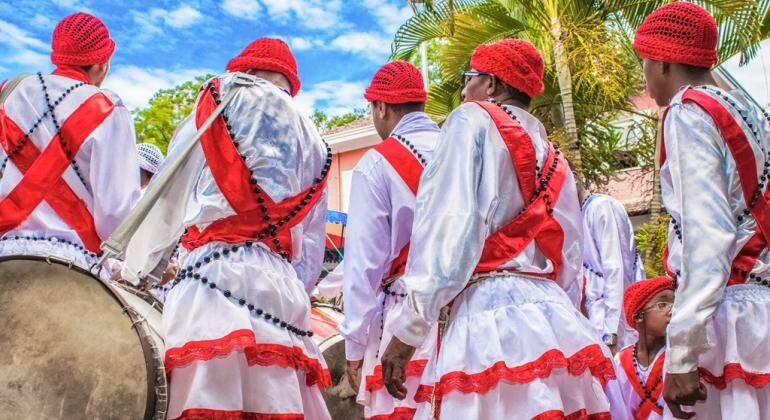 Imagem ilustrativa para o Prêmio Mestres da Cultura Popular de Belo Horizonte. Cinco integrantes com vestimentas brancas e vermelhas, um deles de mãos dadas a uma criança com vestimenta branca e vermelha.