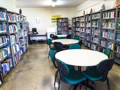 Espaço reservado para leitura com mesas e exposição de livros 