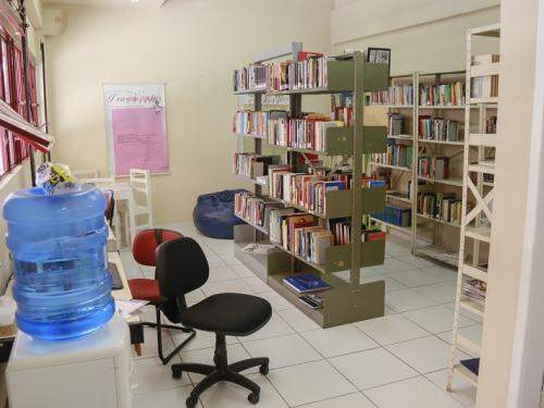 Espaço reservado para leitura com mesas e exposição de livros 