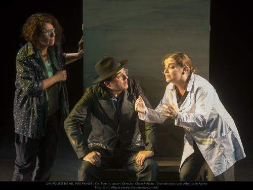 Os três atores da peça contracenando durante o espetáculo