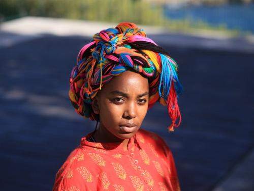 Fotografia de uma mulher com traços africanos e turbante colorido 