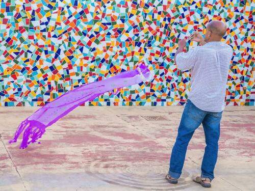 homem segurando um tecido colorido que se movimenta no ar 