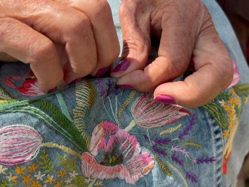 Moça bordando flores em um tecido 