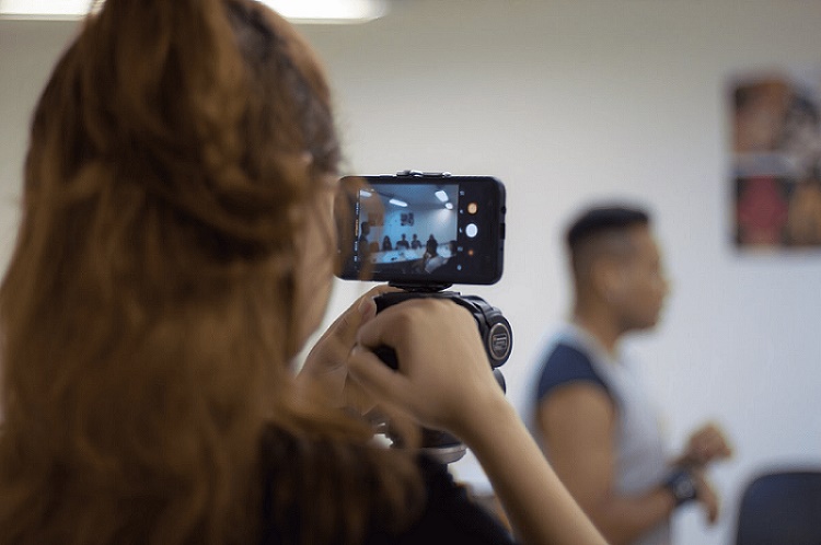 Mulher de costas filmando 