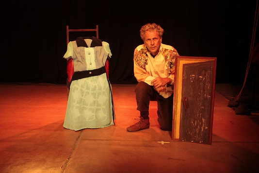 Homem agachado ao lado de um vestido 