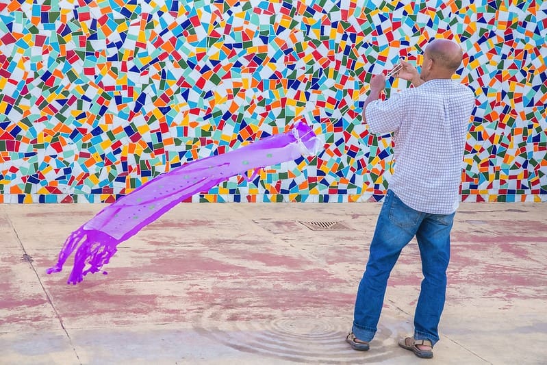 homem segurando um tecido colorido que se movimenta no ar 
