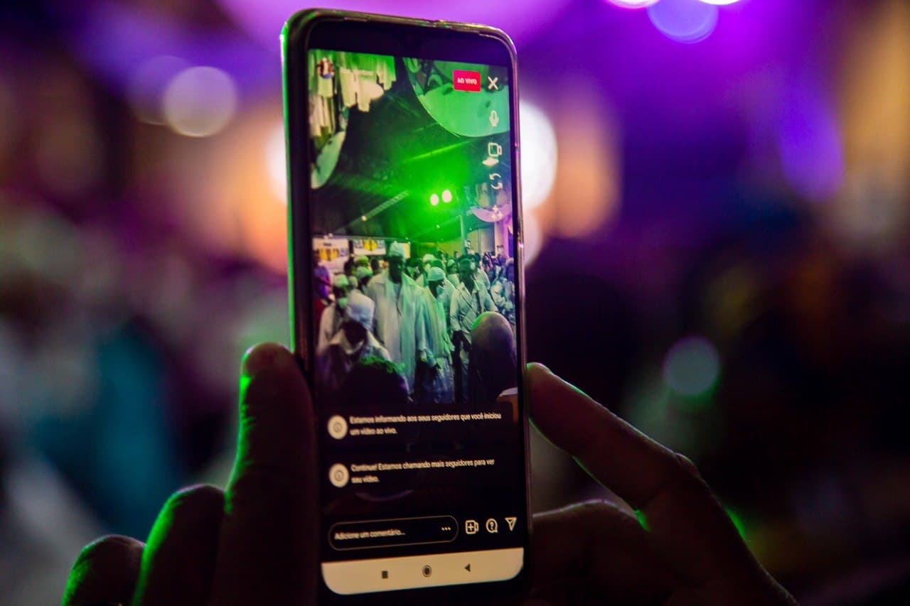 Na imagem, uma live de uma atração do festival é realizada pelo celular. 