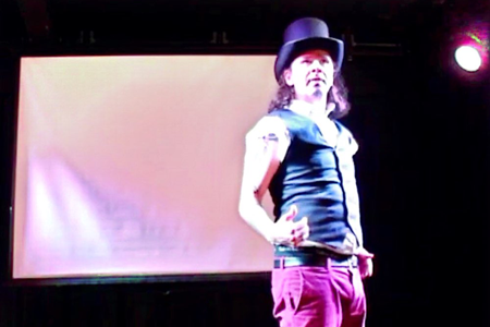 Homem de cartola no palco de um teatro