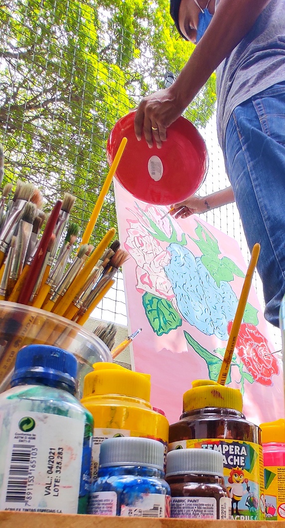 Painel sendo pintado por uma pessoa 