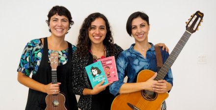 Três mulheres sorrindoO Amaranto, formado pelas irmãs Flávia, Lúcia e Marina Ferraz, apresenta o show “Amaranto para Crianças”, que traz canções de seus trabalhos voltados ao público infantil. O CD "Três Pontes", e os livros/CD “A Menina dos Olhos Virados” e “O Menino das Cem Palavras” são a base desta apresentação que promete encantar crianças e adultos. MAIS INFORMAÇÕES: Virada Cultural de Belo Horizonte 2023 Participação gratuita. e segurando livros e instrumentos musicais em um fundo branco.