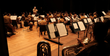 Foto mostrando a Orquestra Sinfônica da Polícia Militar tocando. 