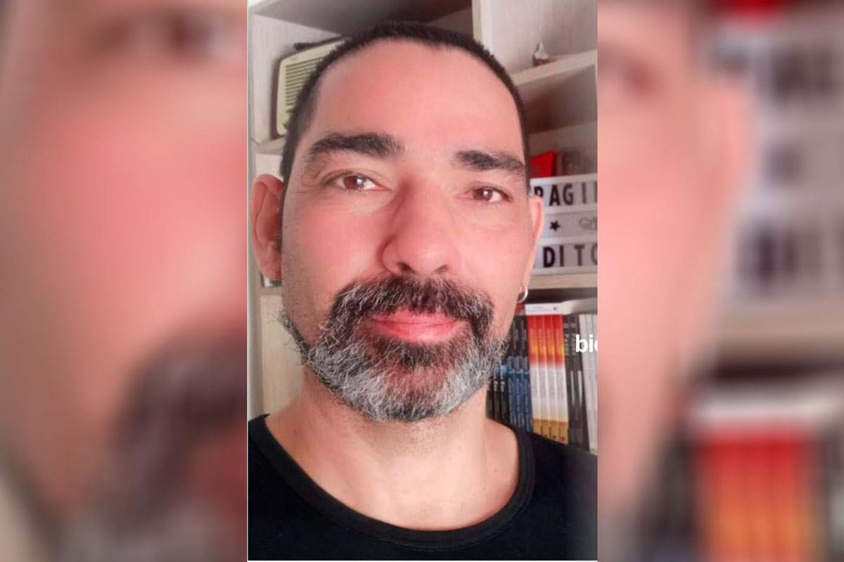 Homem branco, de cabelos escuros e muito curtos, olhando para frente.