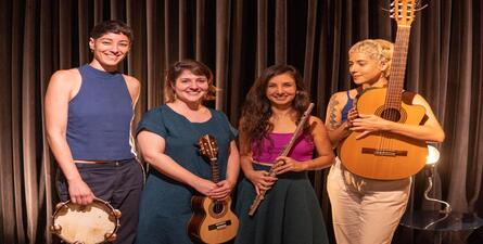 Imagem real de quatro mulheres segurando instrumentos musicais 
