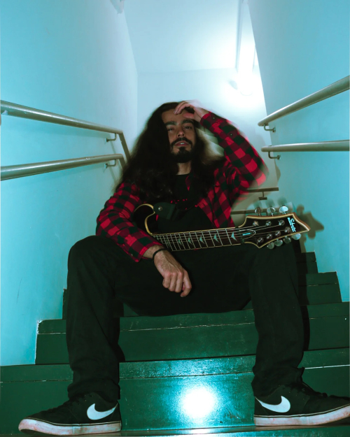 um homem na escada com uma guitarra na mão