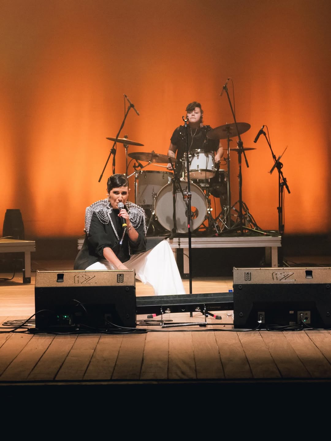 Fotografia da artista Amandona no palco se apresentando 