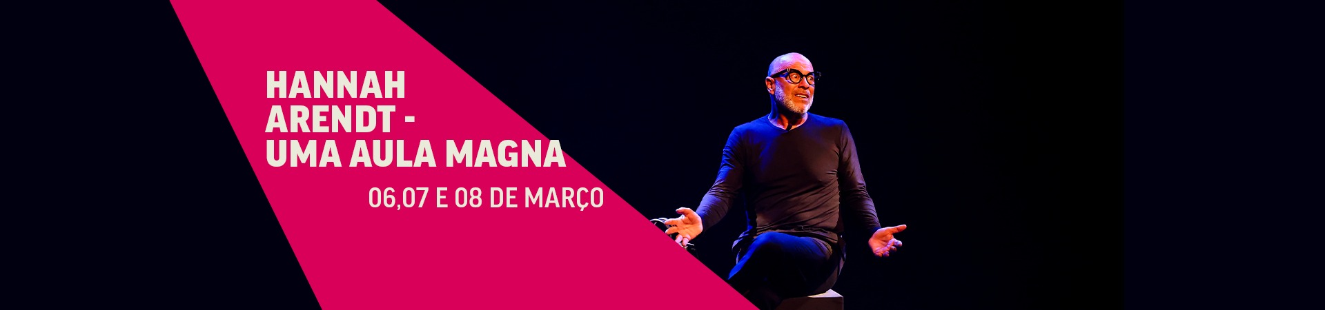 Folder de divulgação da apresentação artística "Hannah Arendt – Uma Aula Magna". À direita, homem sentado em um banco, usando blusa de manga longa e calça com cores escuras enquanto gesticula. Imagem dividida em fundo preto e rosa, com informações sobre o espetáculo – título e datas.