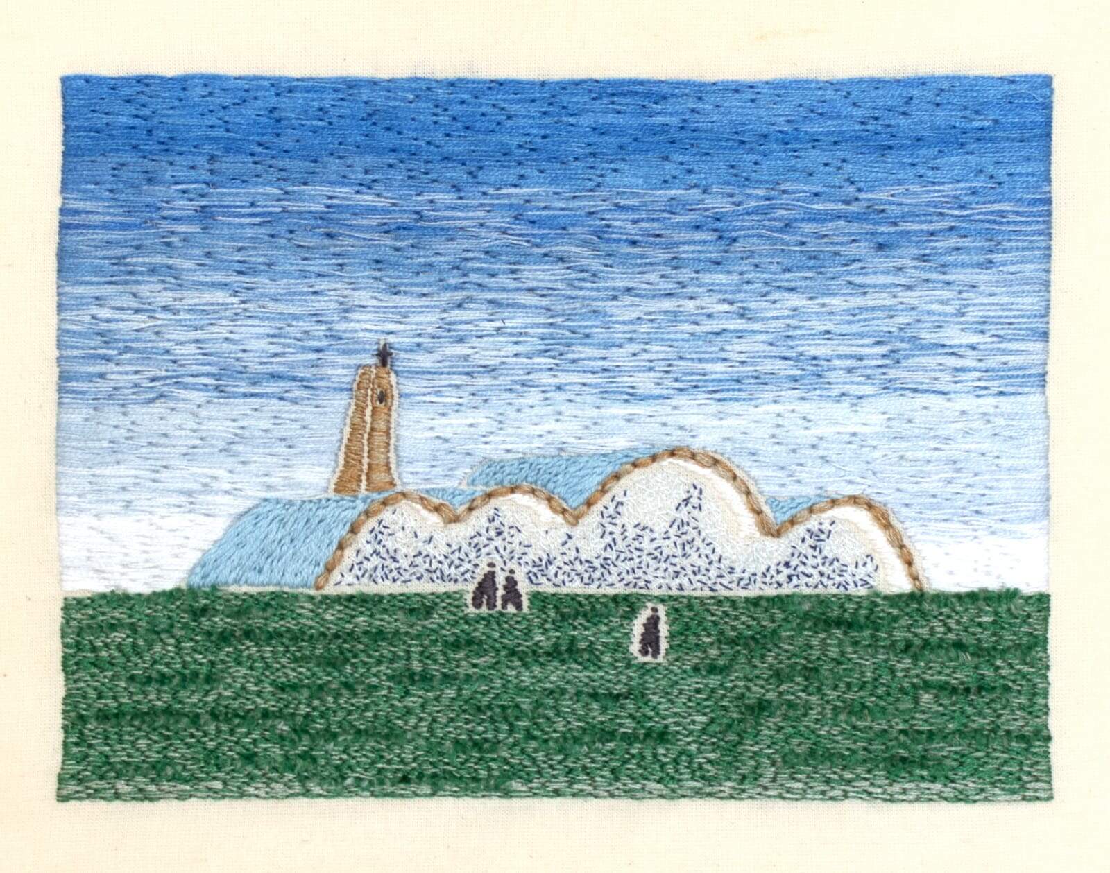Imagem apresenta um bordado que ilustra a Igreja São Francisco de Assis. A arte revela tons de azul e uma parte em verde, que representa o gramado.