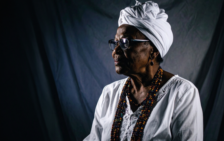FOTO: Divulgação Imagem de uma mulher negra com vestes típicas brancas usadas em religiões de matriz africana.