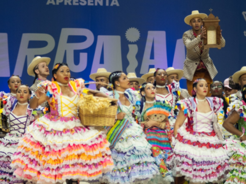 Imagem de um grupo de quadrilha junina se apresentando no Arraial de Belô