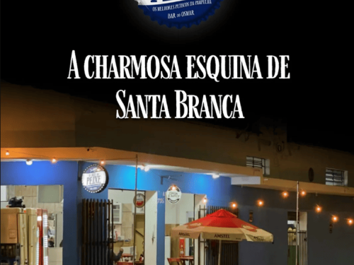 Imagem de um bar, com cadeiras e meses na rua.