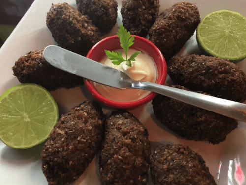 Imagem de kibes fritos e molho no meio