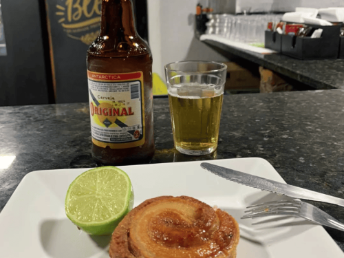 Imagem de uma cerveja e um copo lagoinha, com um torresmo de rolo e limão