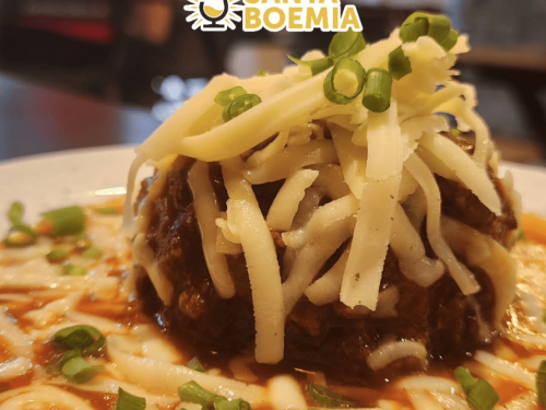 Imagem de uma almondega com queijo ralado em cima 