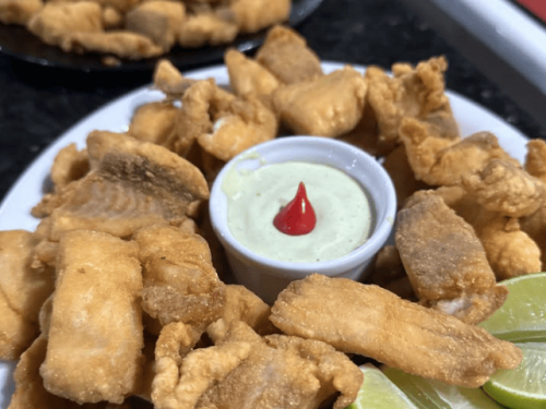 Porção de filé de tilápia crocante com molho especial da casa