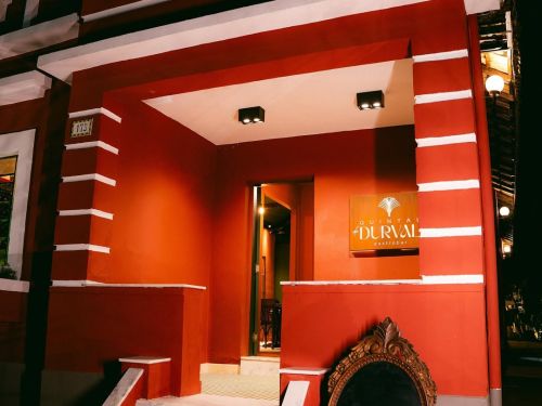 Foto da entreda do restaurante Quintal do Durval, com paredes pintadas em tom de vermelho com detalhes brancos