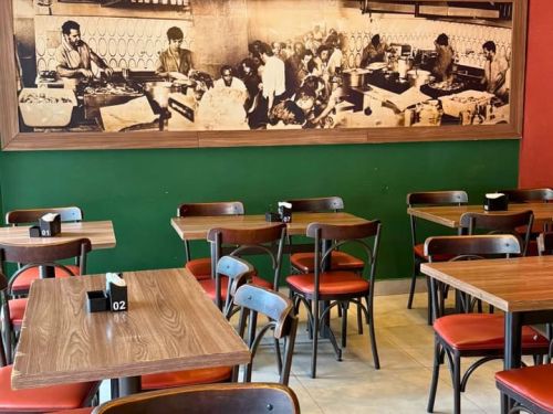 Foto do espaço interno do Resutante e Bar Sheridan com cadeiras e mesas de madeira 