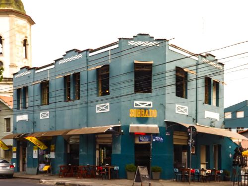 Foto da faichada do Restaurante Sobrado com a parede azul e letreiro com o nome do espaço em amarelo 