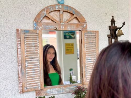 ambiente do restante uma moça na janela com uma plaquinha em espanhol