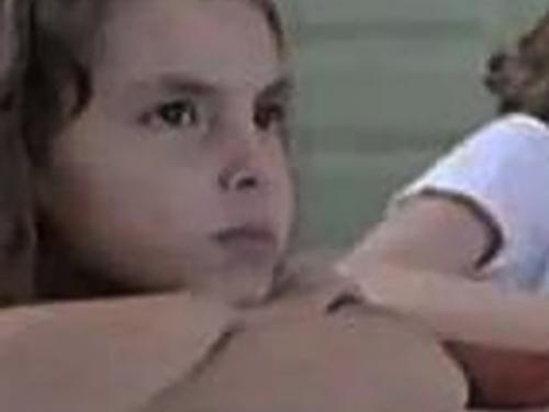 Foto de uma menina com os braços cruzados, com um semblante pensativo