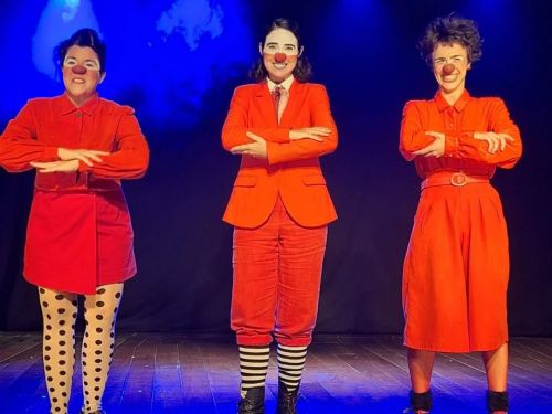 Descrição da imagem: três pessoas com nariz de palhaço, vestindo roupas vermelhas.