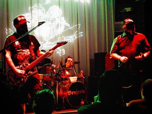 2 homens com faixa no rosto tampando do nariz para baixo de blusa preta 