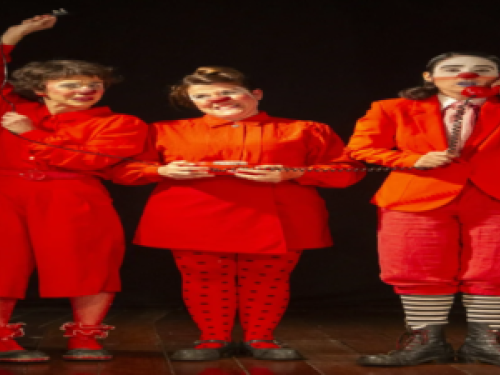 Descrição da imagem: três pessoas com nariz de palhaço, vestindo roupas vermelhas.