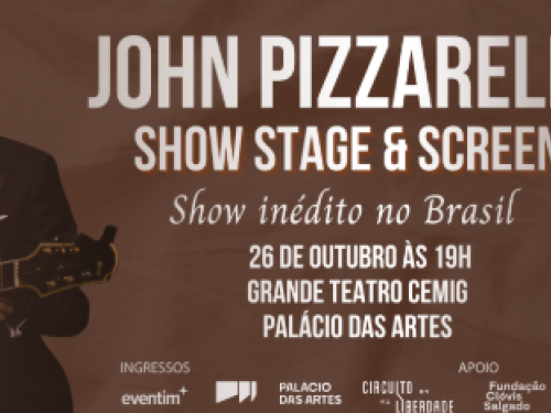 Imagem com um homem segurando o violão e sorrindo 