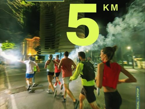 Foto noturna de corredores no centro de BH. Em destaque, o texto “Percurso Corrida Central 5km”. Ao fundo, prédios iluminados e fumaça dão o clima vibrante da prova.