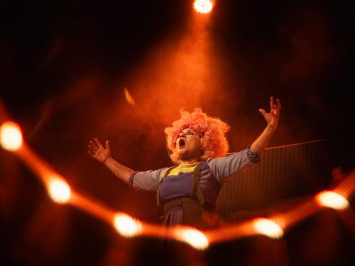 Três pessoas com roupas coloridas e portando brinquedos