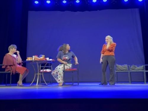 Duas mulheres e uma adolescente sentadas à mesa