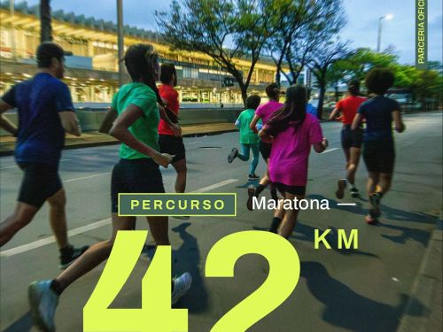 Foto de corredores em movimento, no asfalto, durante a noite. Em destaque sobre a imagem, o texto em amarelo neon: “Percurso – Maratona 42km”