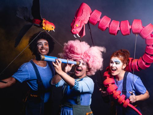 Três pessoas com roupas coloridas e portando brinquedos