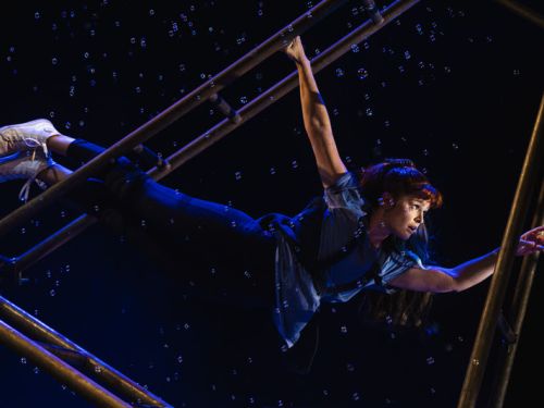 Três pessoas com roupas coloridas e portando brinquedos