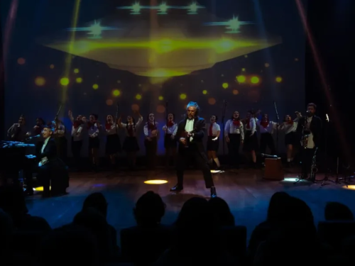 um homem a frente de vários cantores 