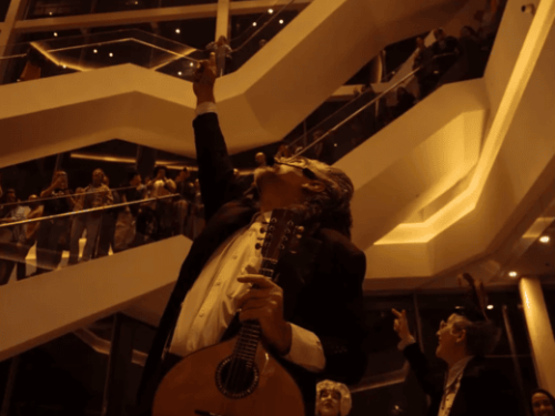 um homem com traje fino apontando para cima com um instrumento para cima 