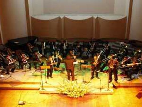 Imagem Ilustrativa de um grupo de trompetistas dentro de um auditório 