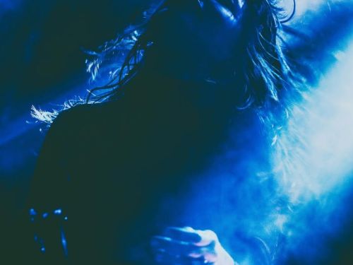 fotografia de jogo de luzes azuis no escuro com a cantora Salma Jo ao centro